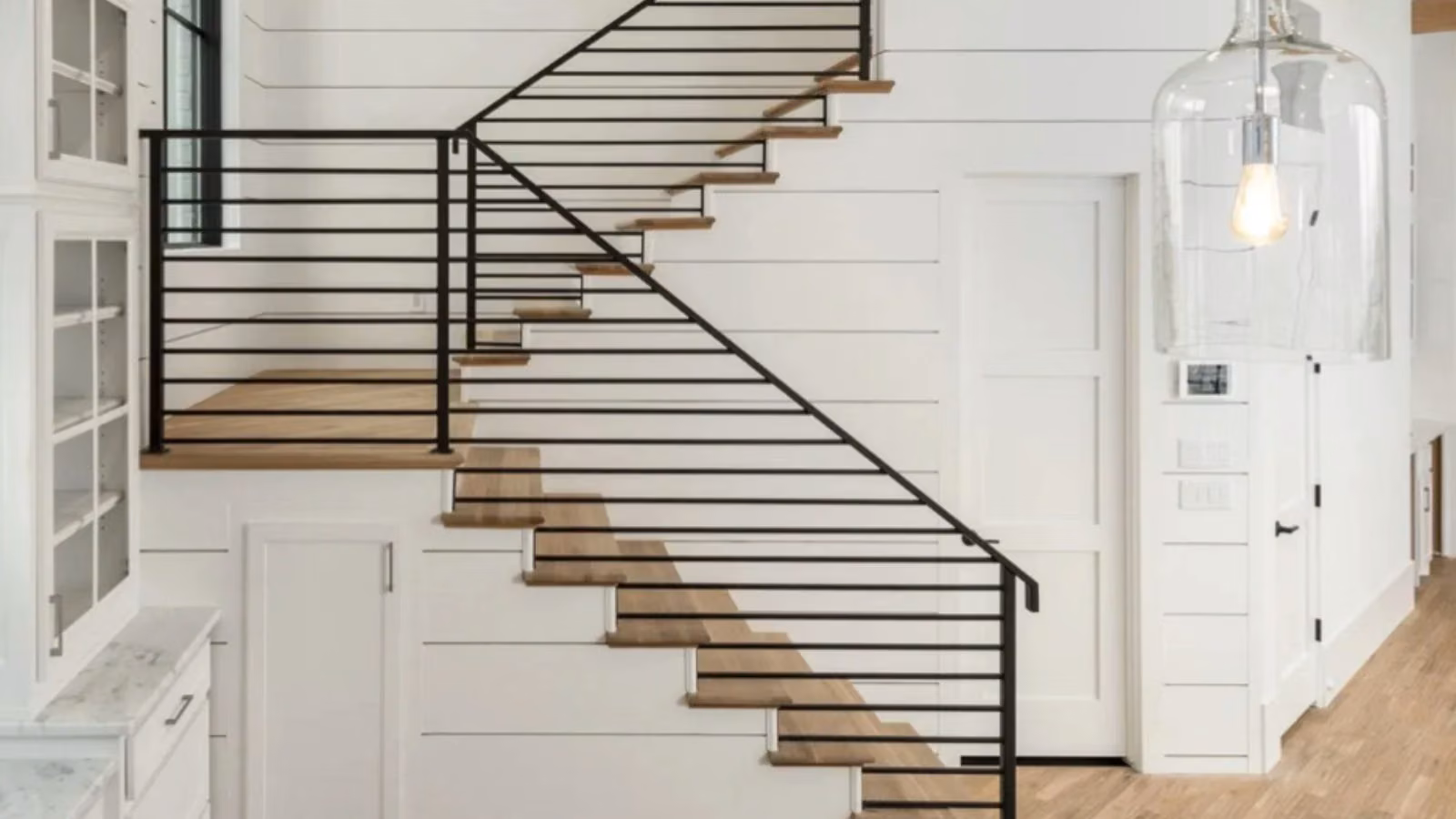 Dated builder-grade staircase in a Dallas-Fort Worth home before remodeling