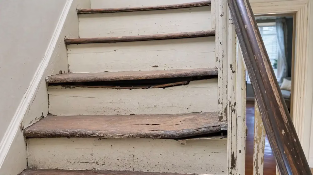 Worn and cracked stair treads with peeling paint and split wood showing structural damage that requires staircase remodeling in a Dallas-Fort Worth home