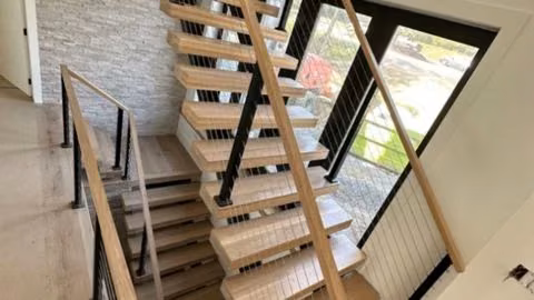 Mixed-material designs (wood treads + iron, glass or cable railings)