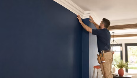 FJR Stair & Door carpenter fitting crown molding at the ceiling